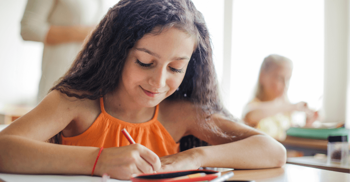 Meisje oefent met Romeinse cijfers aan tafel in de klas op de basisschool