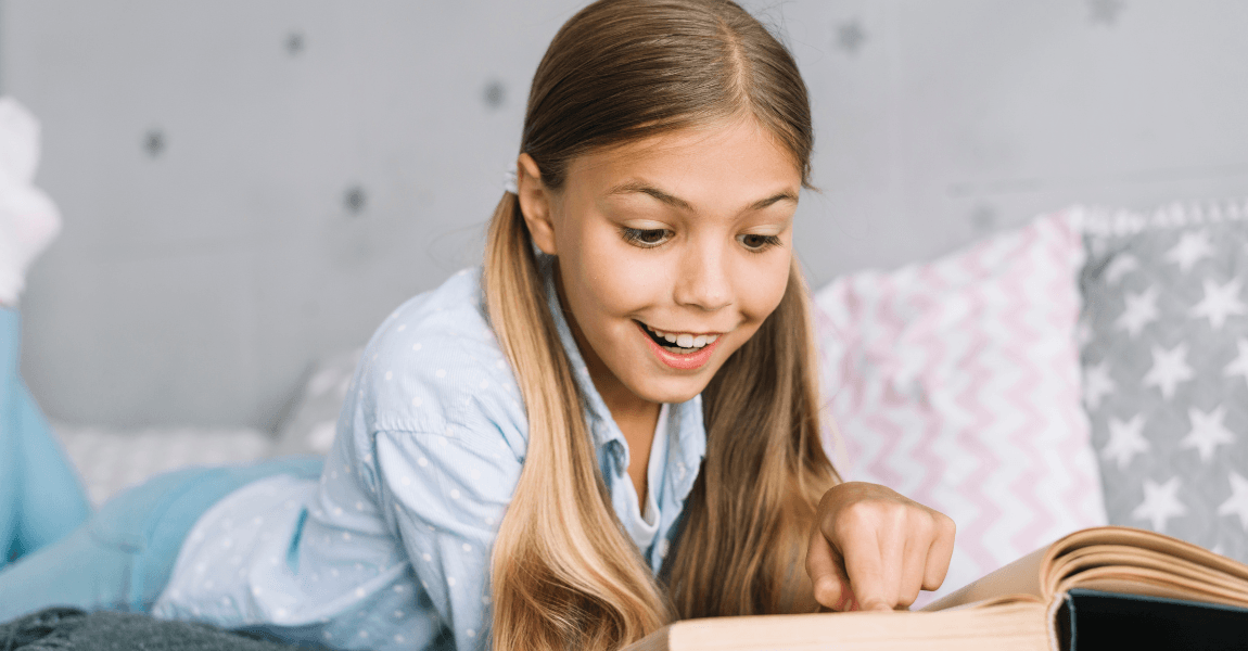 Kind uit groep 8 oefent thuis met begrijpend lezen en leest aandachtig in een boek aan tafel.