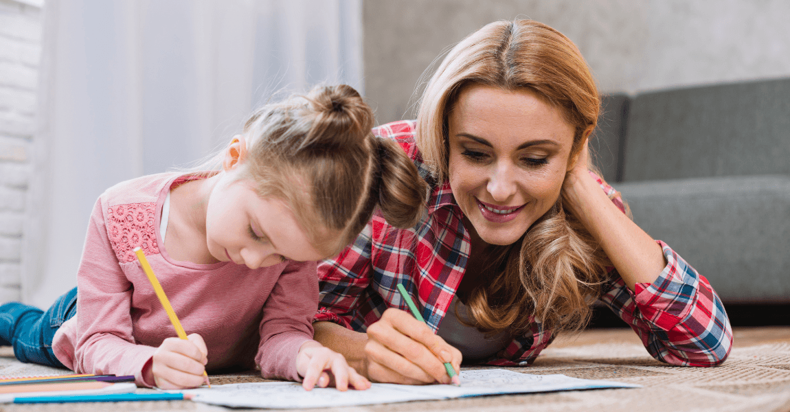 Moeder helpt haar kind thuis met schrijven en oefenen op de vloer als voorbeeld van oefenboeken basisschool en extra oefenen thuis