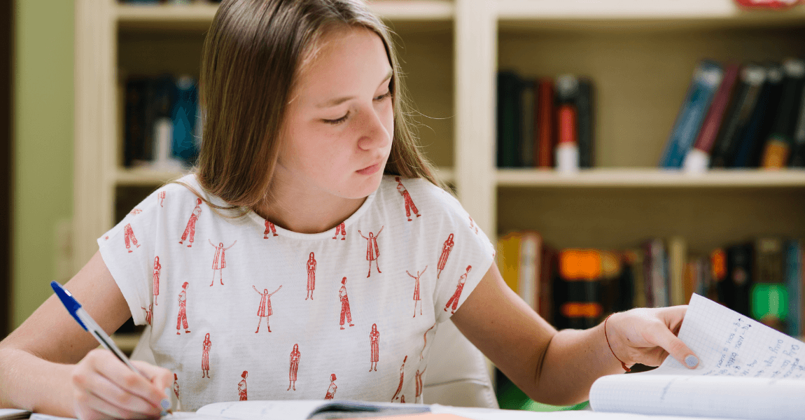 Meisje uit groep 8 oefent thuis voor de IEP Doorstroomtoets met schoolwerk en schrift