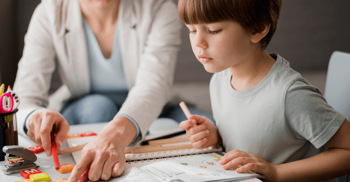 Intern begeleider basisschool begeleidt een kind tijdens een rustig oefenmoment aan tafel