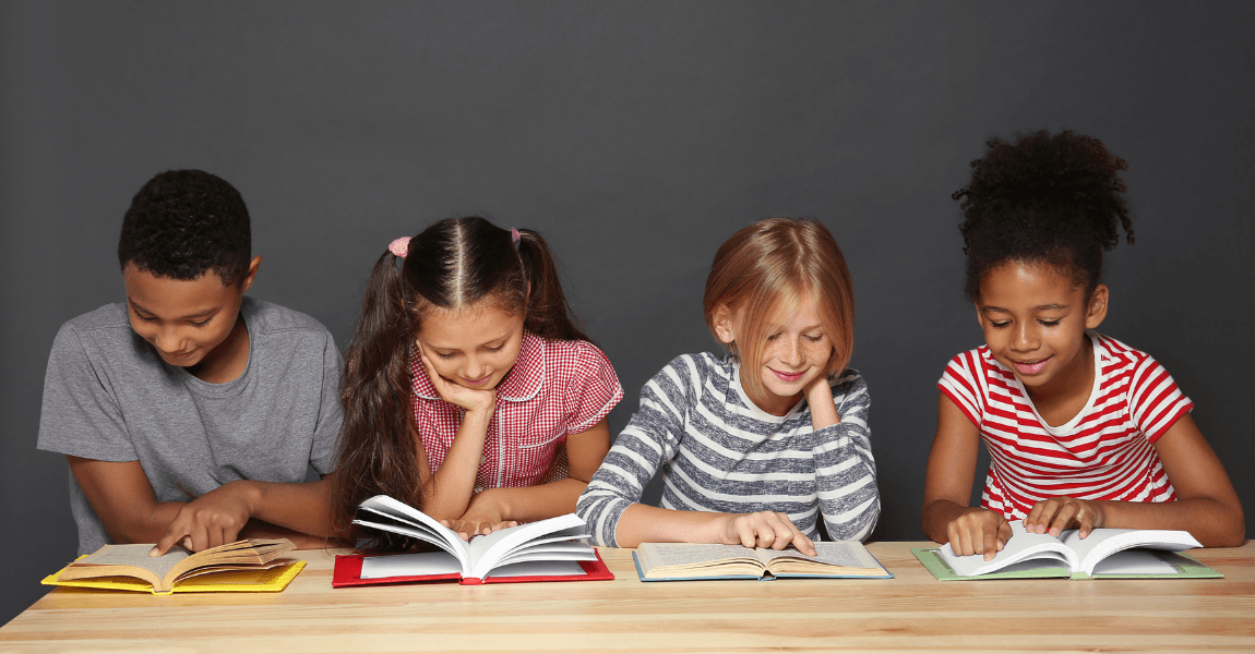 Kinderen uit groep 6 oefenen begrijpend lezen samen aan tafel met open boeken.