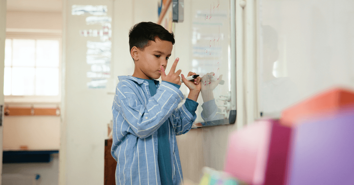 Kind oefent contextopgaven en rekenen op de basisschool met uitleg aan het whiteboard