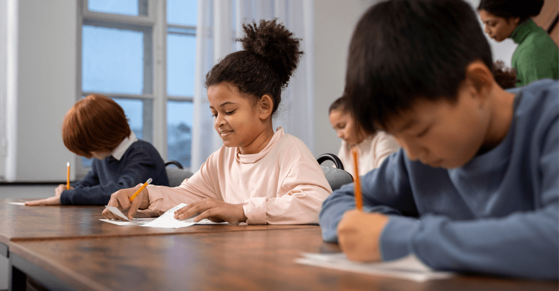 Kinderen in de klas maken een leerpotentietest op de basisschool terwijl ze geconcentreerd aan hun opdrachten werken