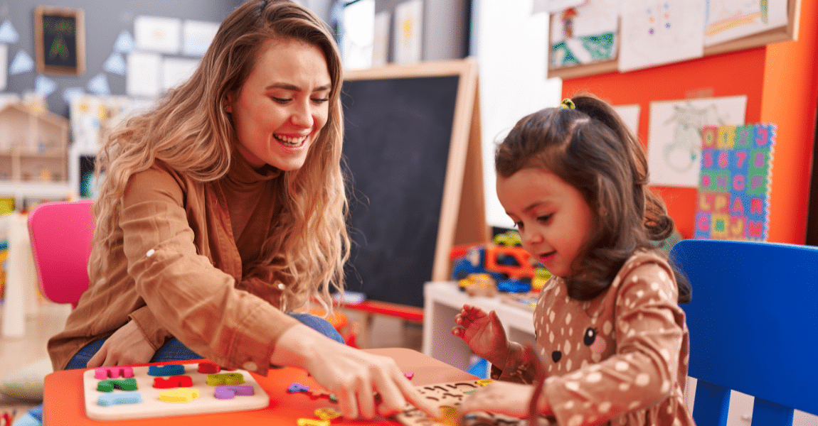 Moeder oefent thuis spelenderwijs met haar kind voor leren lezen in groep 3 aan tafel met letters en educatief materiaal