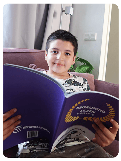 Jongen leest in een oefenboek begrijpend lezen voor groep 6 van Oefenboeken.nl