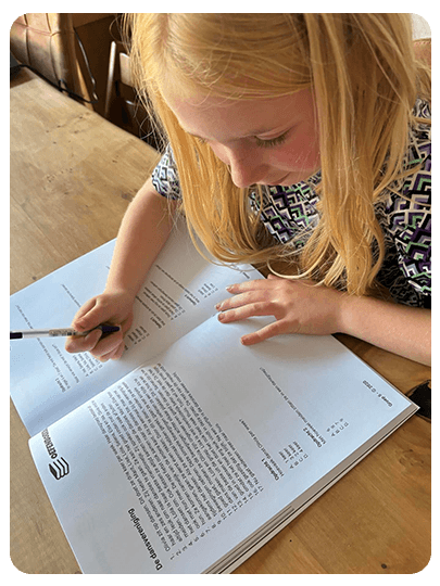 Meisje oefent spelling in een oefenboek als voorbereiding op de Cito-toets basisschool