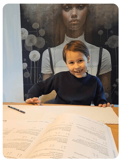 Lachend kind oefent rekenen met oefenboeken voor de basisschool op de keukentafel