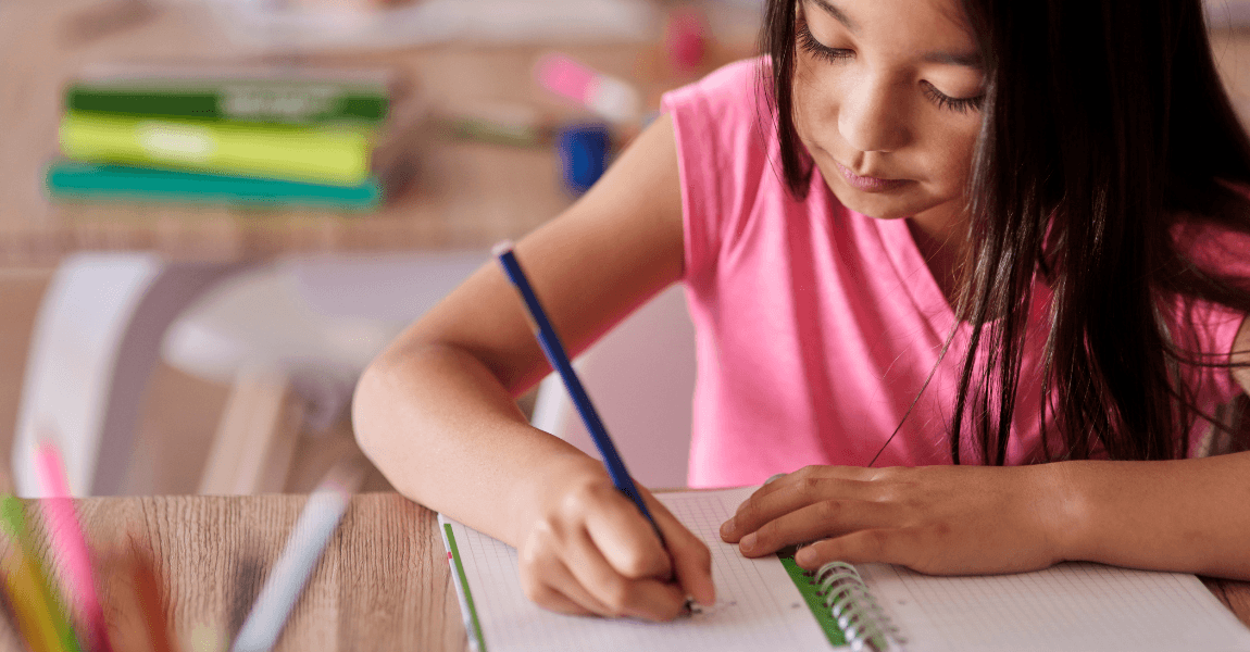 Meisje oefent met au of ou in groep 4 in een schrift aan tafel thuis