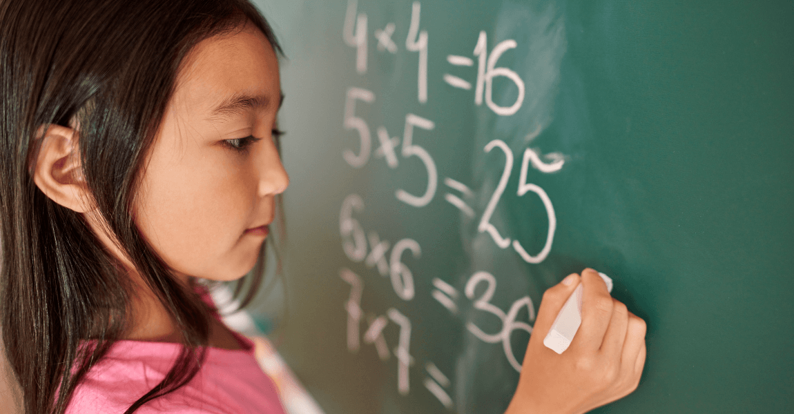 Kind oefent rekenen groep 5 op een schoolbord met keersommen en rekensommen
