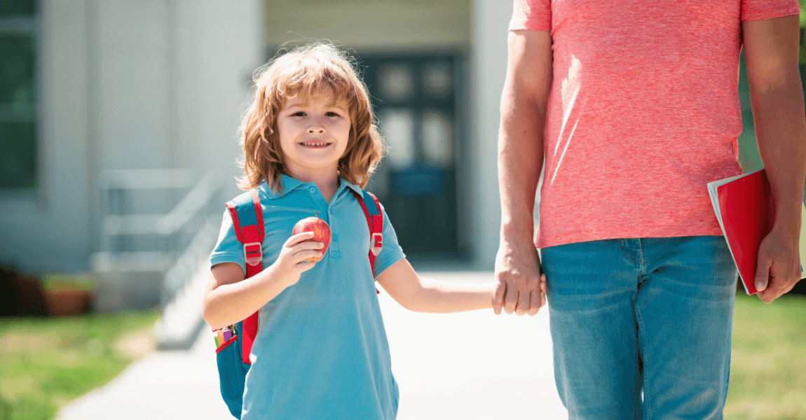Kind loopt met ouder naar de basisschool als beeld bij wanneer inschrijven basisschool en de start op school
