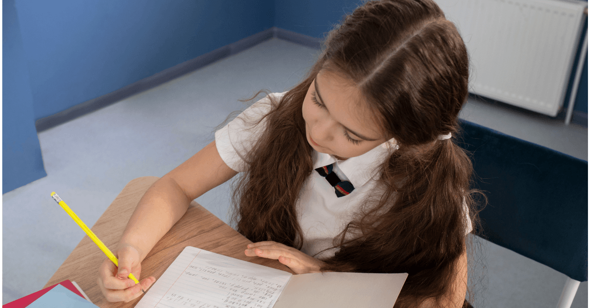 Kind op de basisschool oefent met zinnen ontleden in een schrift aan tafel.