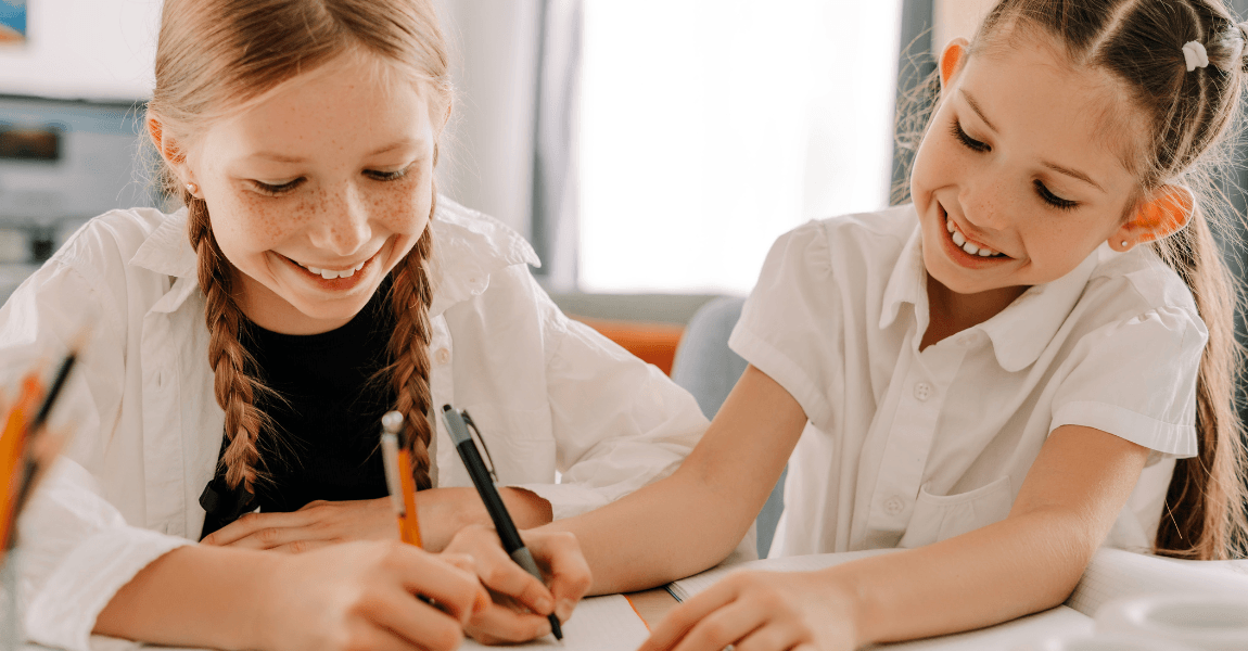 Twee kinderen oefenen samen categorie spelling en spellingwoorden aan tafel op de basisschool.