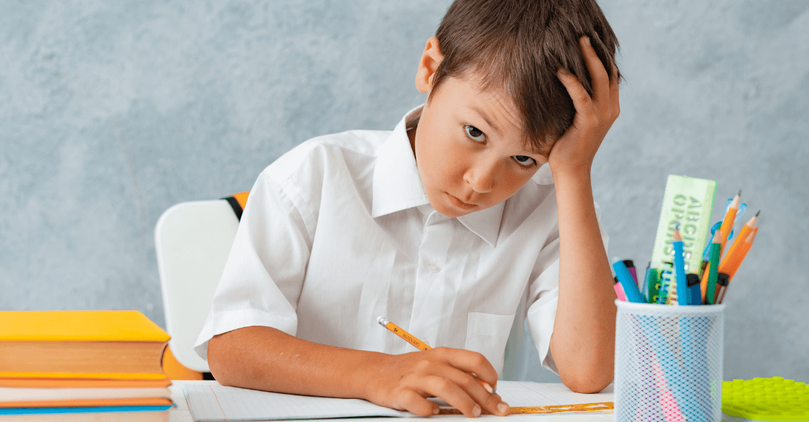 Kind op de basisschool dat geconcentreerd oefent na een D score bij een toetsresultaat.