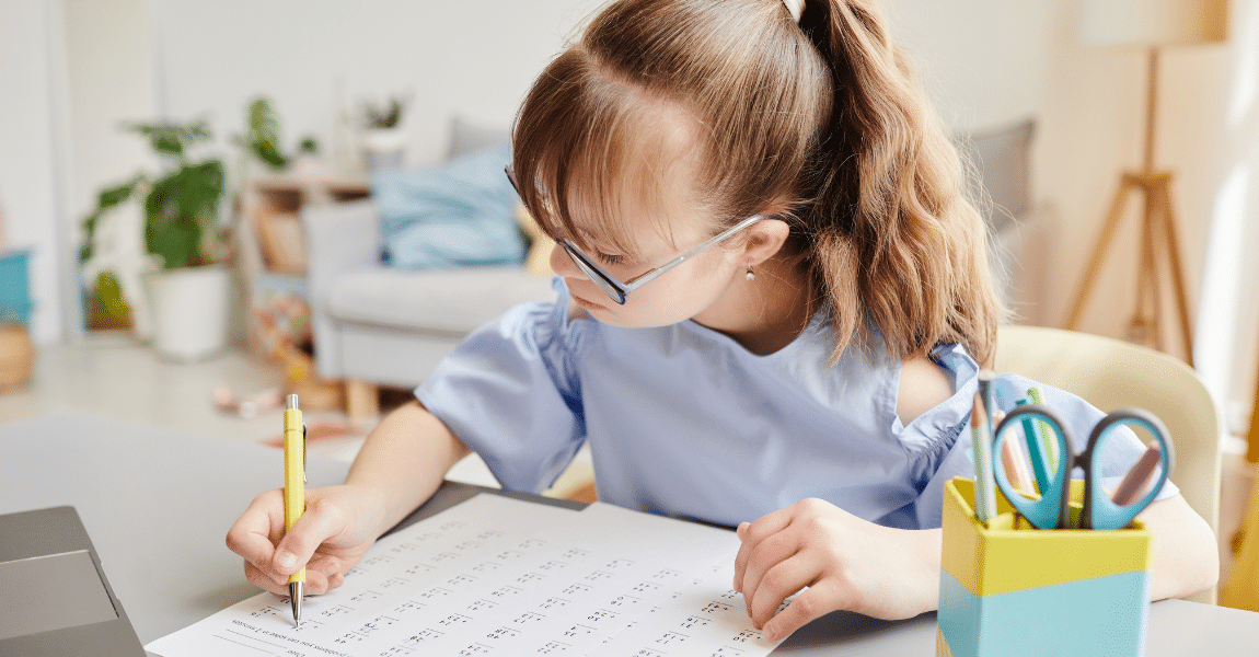 Kind oefent thuis deelsommen met rest op een werkblad voor rekenen op de basisschool.