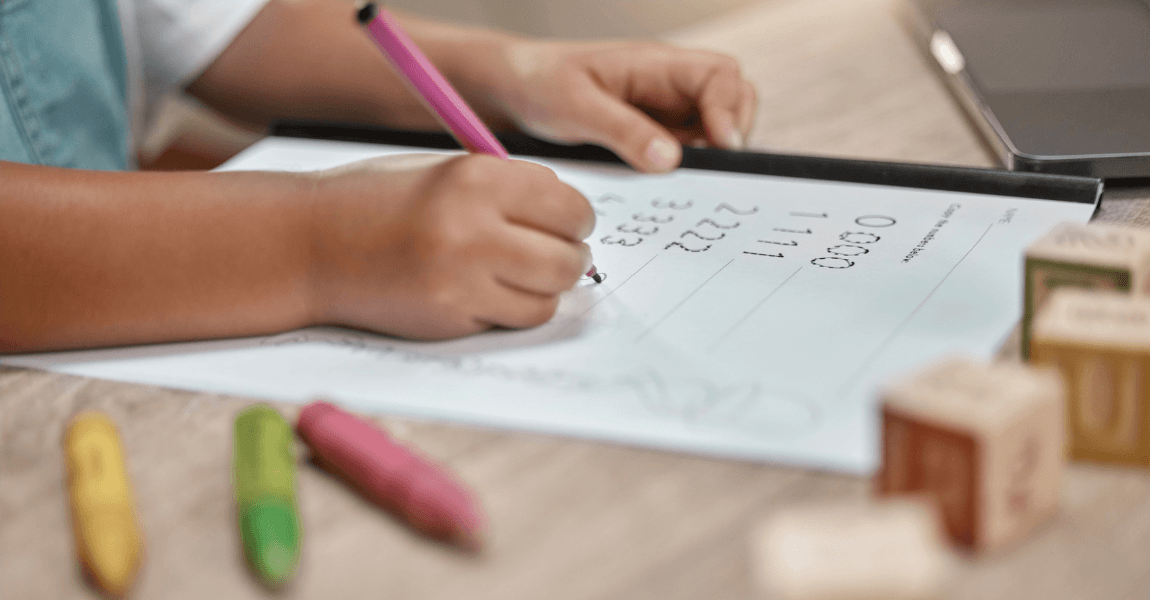 Kind uit groep 3 oefent rekenen met de getallenlijn tot 100 op een werkblad aan tafel.