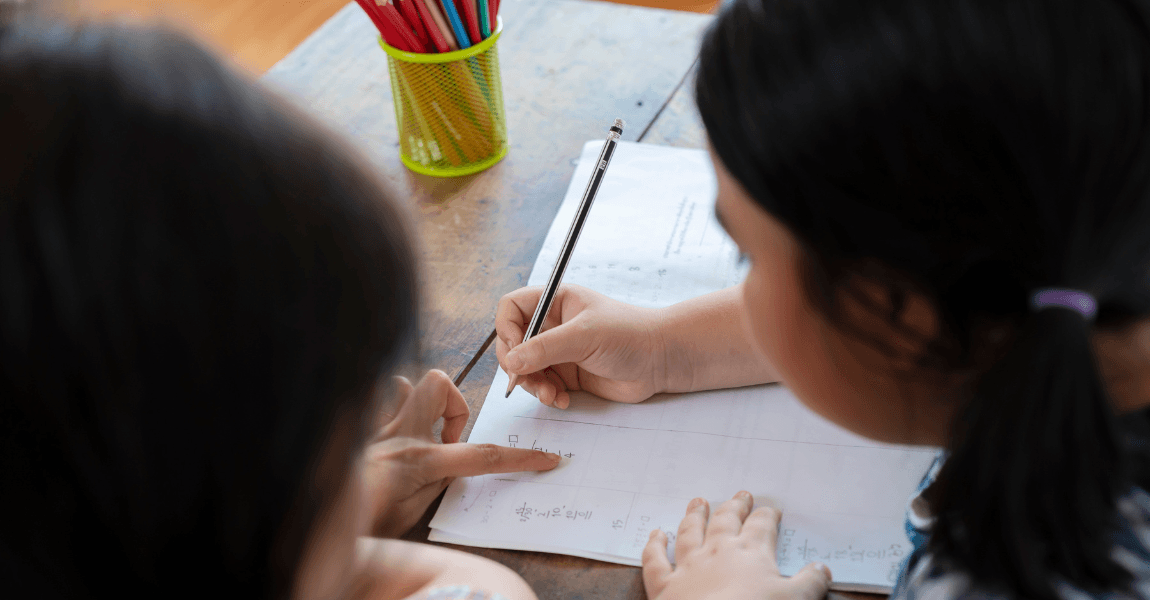 Kind oefent met rekenen en inhoudsmaten zoals liters en kuub tijdens het maken van schoolwerk aan tafel.