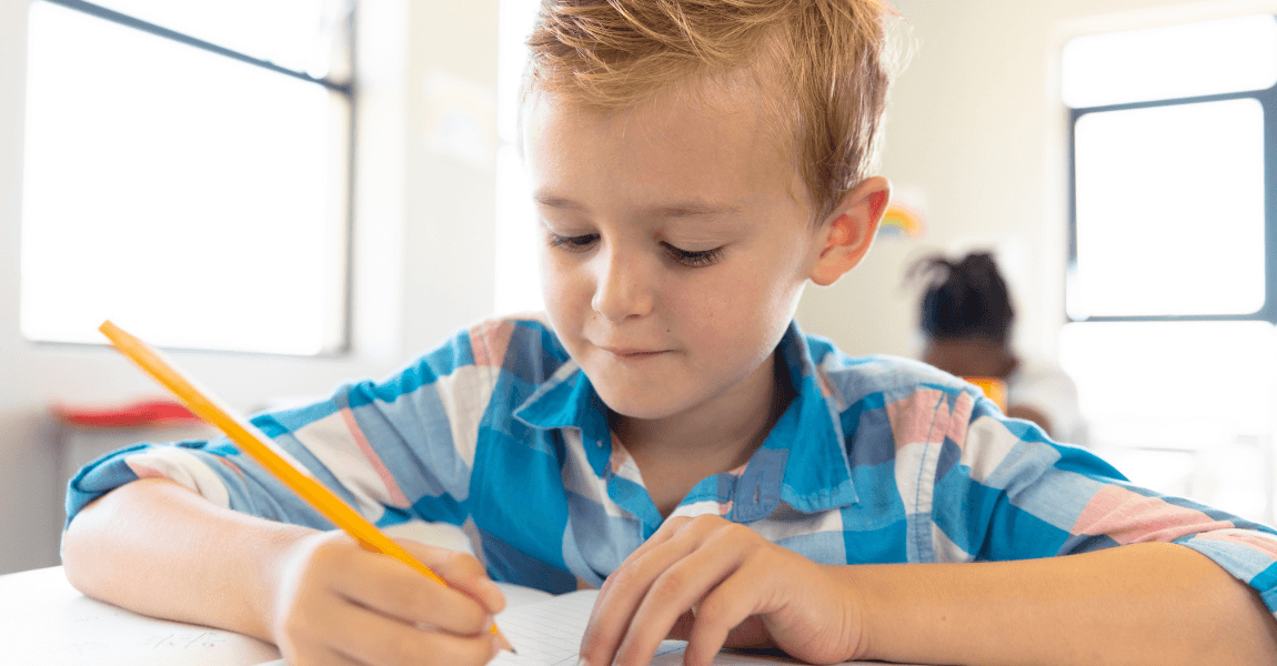 Kind oefent hoofdletters en schrijfletters in een schrift, waaronder de hoofdletter S als schrijfletter.