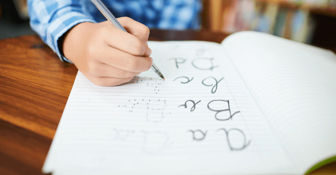 Kind oefent hoofdletters en schrijfletters schrijven in een schrift met pen.