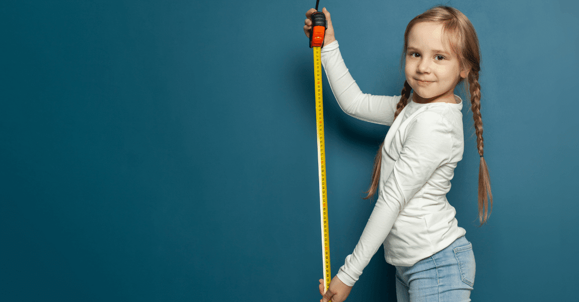 Kind oefent met lengtemaat door te meten met een meetlint, passend bij uitleg over lengtematen op de basisschool.