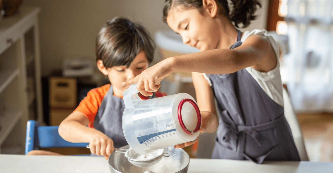 Kinderen oefenen thuis met gram en gewicht tijdens het wegen van ingrediënten voor het metriek stelsel.