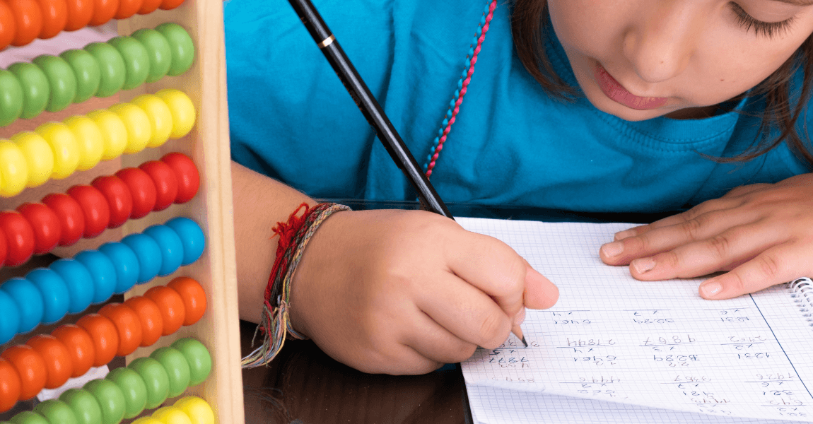 Kind oefent met deelsommen in een schrift naast een telraam, geschikt voor ouders die thuis willen helpen met rekenen oefenen.