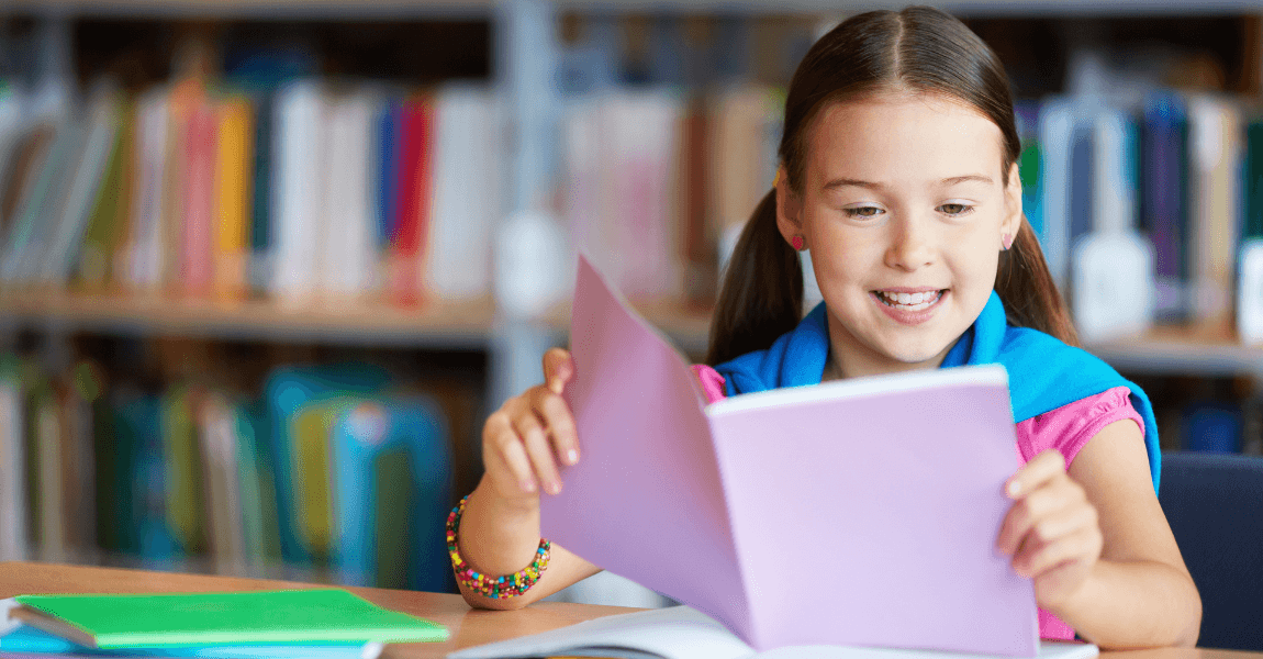 Kind leest een boek en oefent met persoonlijke voornaamwoorden en taal op de basisschool.