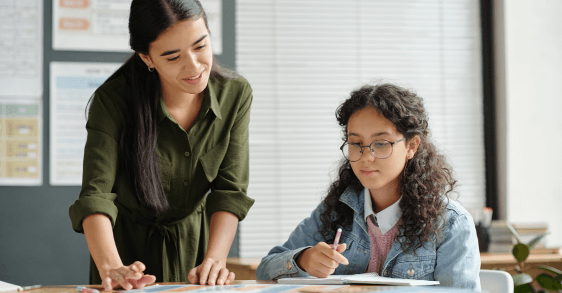 Leerkracht helpt leerling met redekundig ontleden oefenen op de basisschool met uitleg over zinsdelen en grammatica.