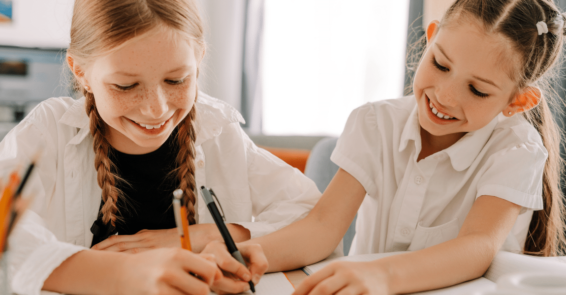 Twee kinderen oefenen samen reken sommen groep 5 aan tafel met pen en papier.
