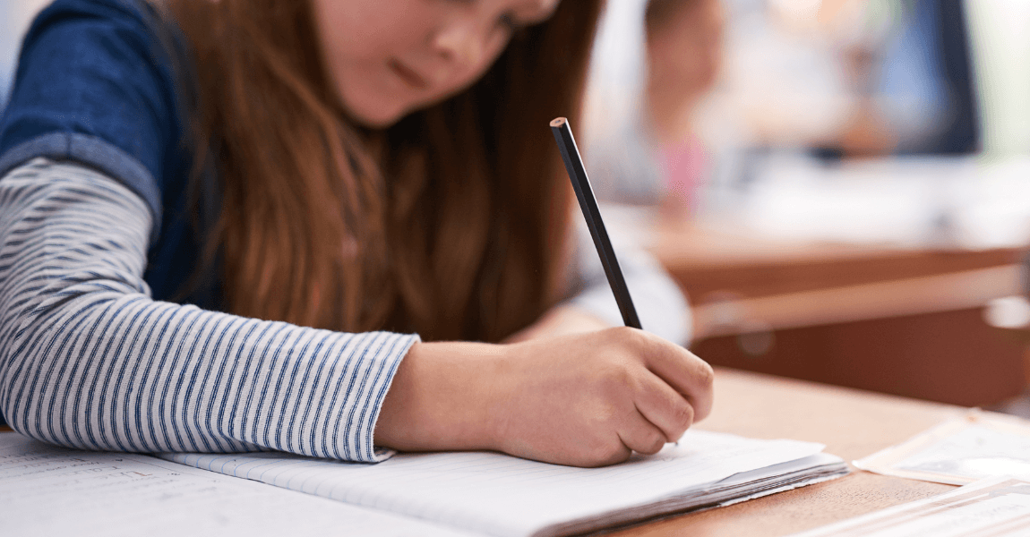 Kind oefent in een schrift met Romeinse cijfers omzetten naar een datum voor school.