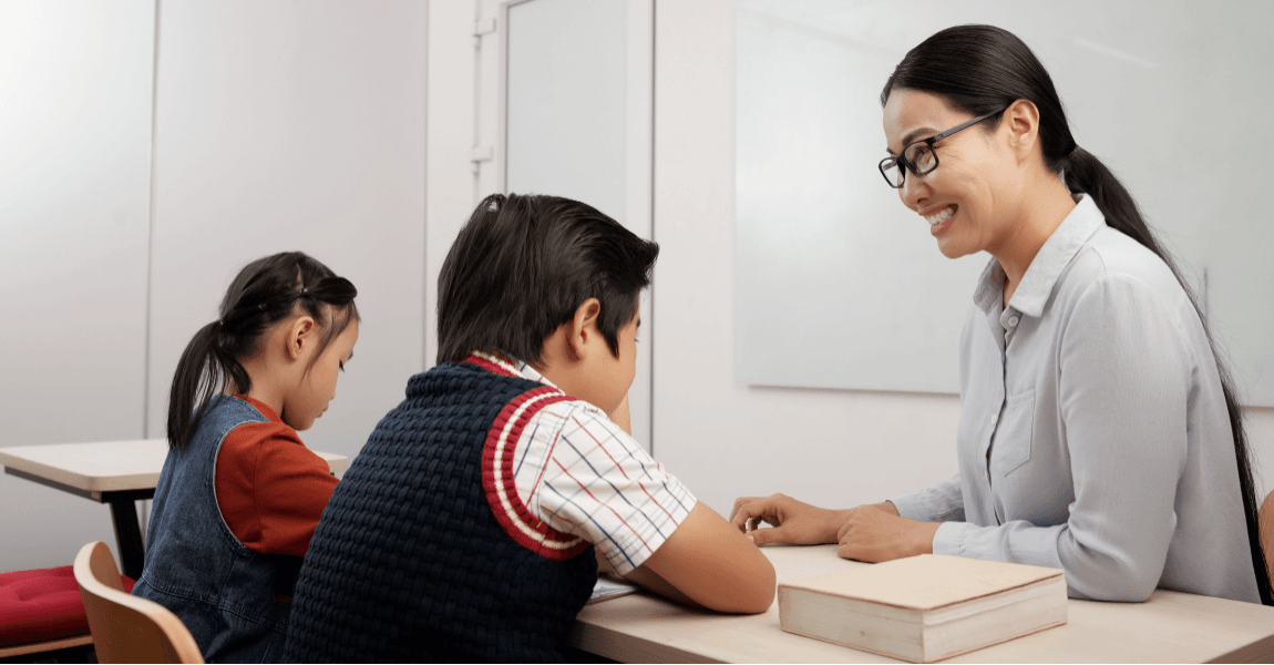 Leerkracht helpt basisschoolkinderen met het oefenen van samengestelde woorden en taalvaardigheid in de klas.