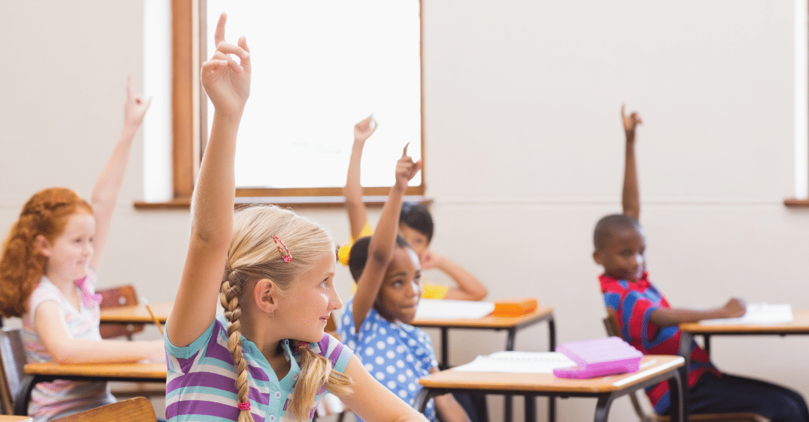 Basisschoolkinderen steken hun hand op tijdens een taalles over ww spelling oefenen en werkwoordspelling.