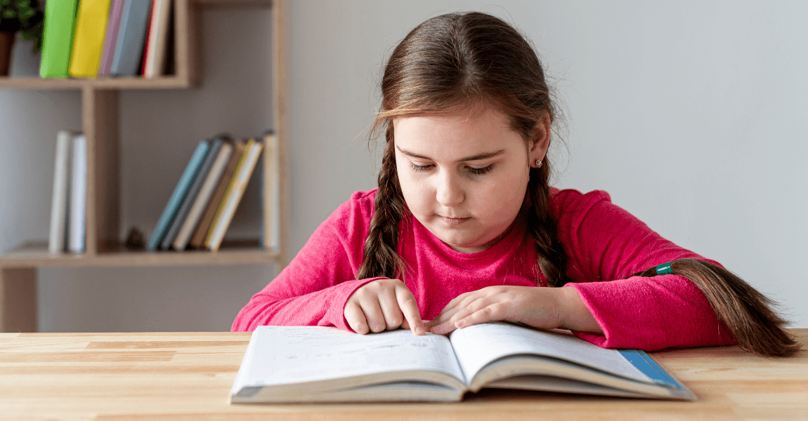 Meisje oefent zwakke en sterke werkwoorden in een boek aan tafel.