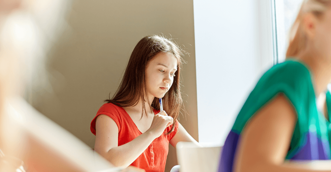 Kind maakt geconcentreerd opdrachten voor de IEP toets op de basisschool ter voorbereiding op rekenen, taal en begrijpend lezen.