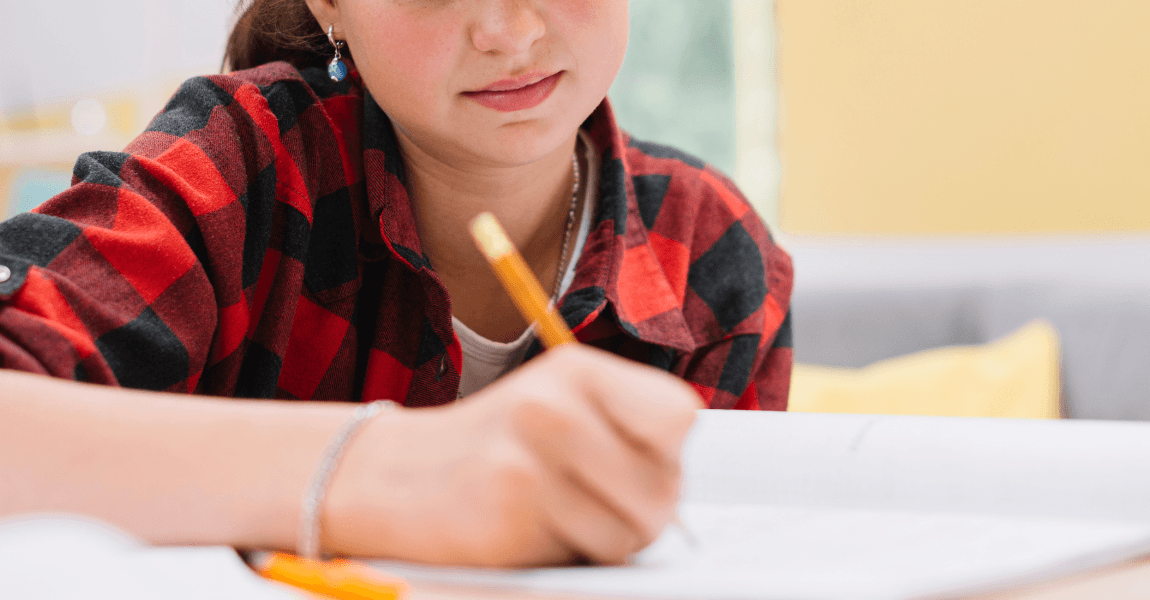 Leerling uit groep 8 oefent Engels voor Cito met een werkblad aan tafel.