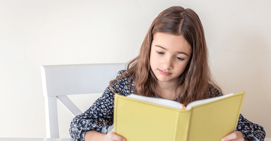 Kind leest een boek en oefent met de betekenis van een gezegde en figuurlijk taalgebruik.