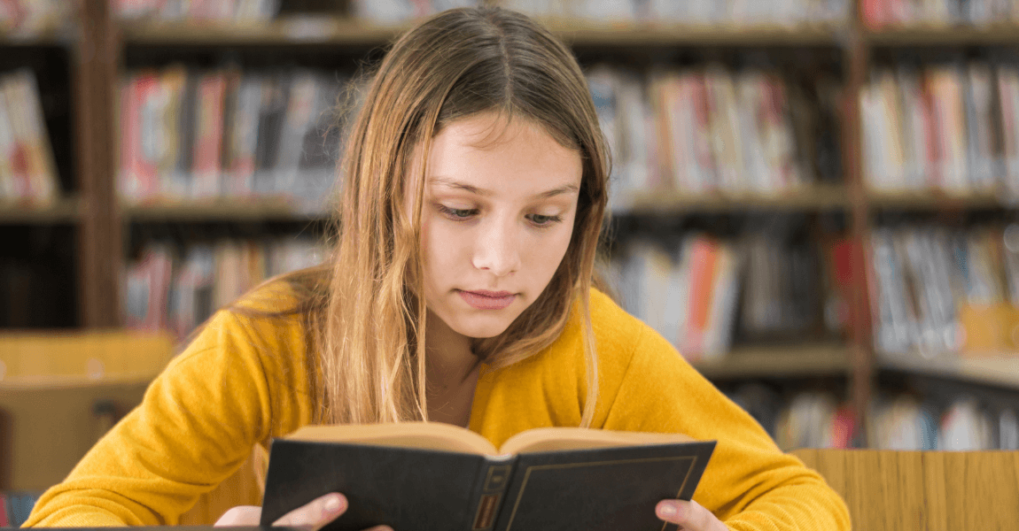 Leerling uit groep 6 leest een boek tijdens het oefenen van taal en spelling