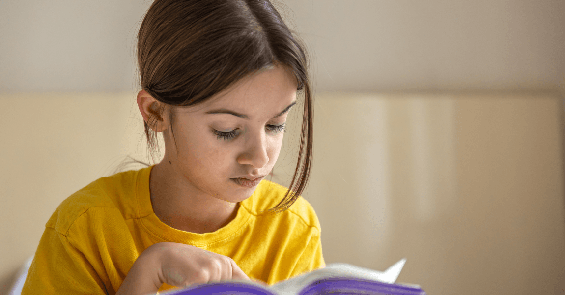 Meisje oefent Nederlandse voorzetsels met voorbeelden en oefeningen in een boek.